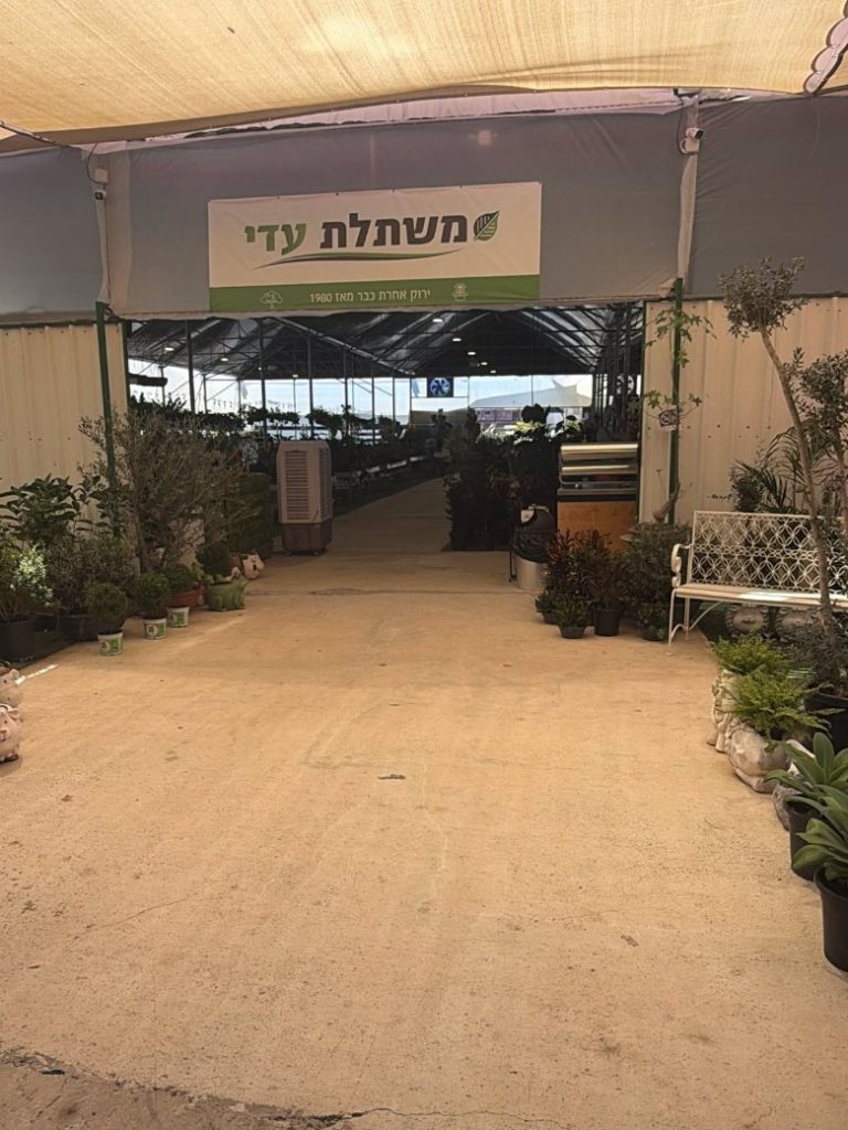 הכניסה למשתלת עדי מתחת לרשת ההצללה, עם השלט ירוק אחרת כבר מאז 1980